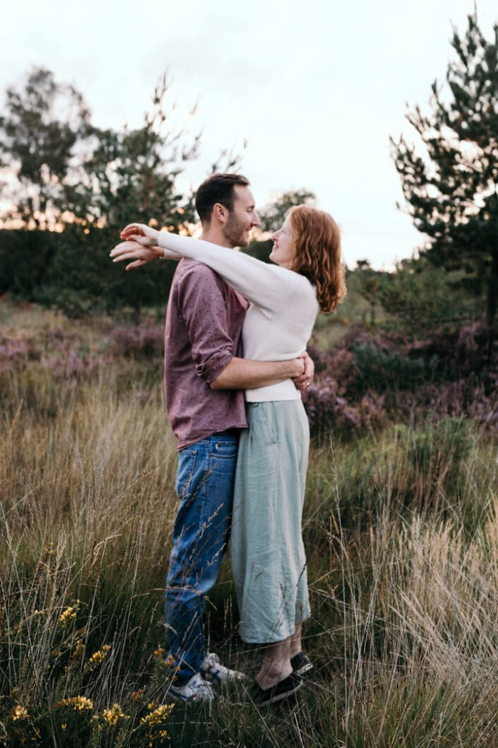 Husband and wife are holding each other. Wife is on her toes and has wrapped straight arms around her husband. Lovely couple photography in Hampshire. Ewa Jones Photography