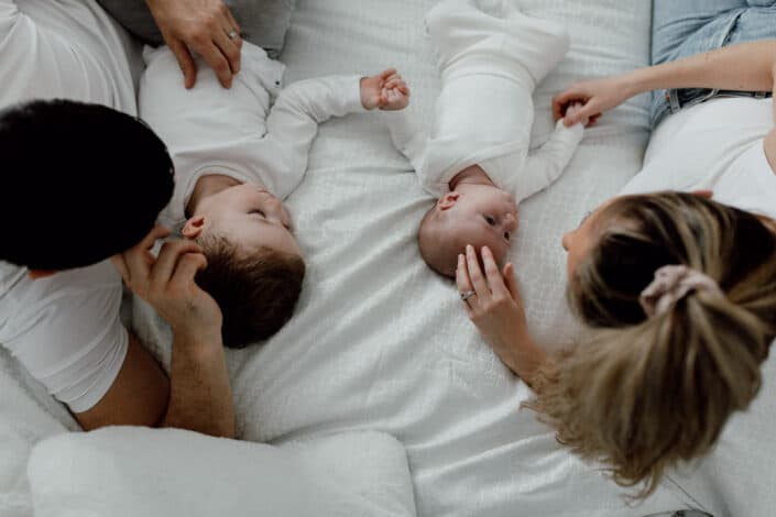 Mum and dad are laying on the bed and looking at their boys. Family photo session in Basingstoke. Ewa Jones Photography