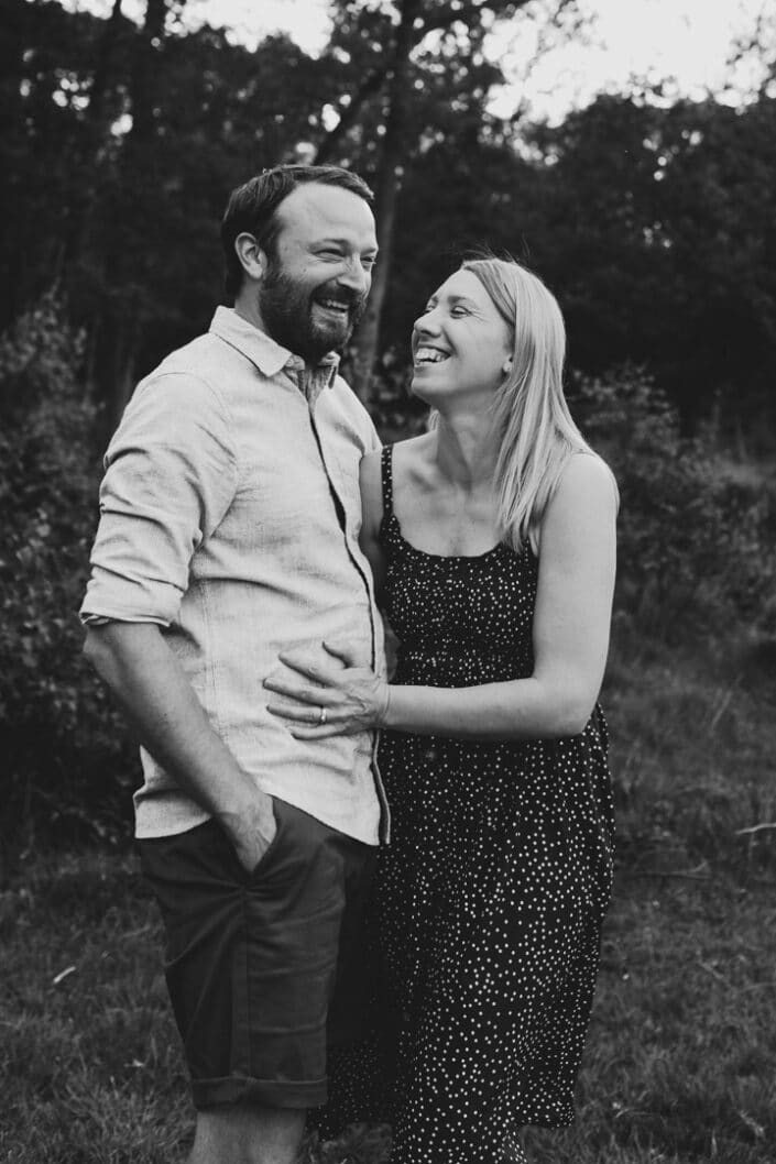 Black and white photograph of mum and dad holding and laughing. Lovely couple photograph in hook, Hampshire. Ewa Jones Photography