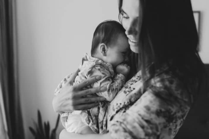 Black and white photograph of mum holding her little baby girl. In home photo session in Hammersmith, London. family photographer. Ewa Jones Photography