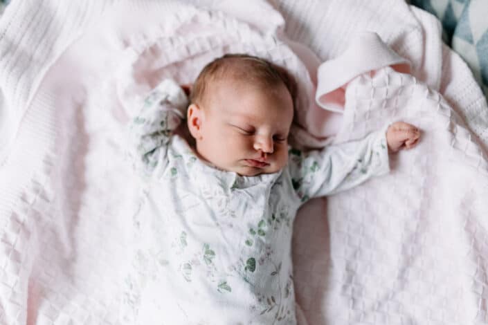 Baby girl is sleeping and she has her hands up. Newborn baby poses. Newborn photography in Fleet, Hampshire. Ewa Jones Photography