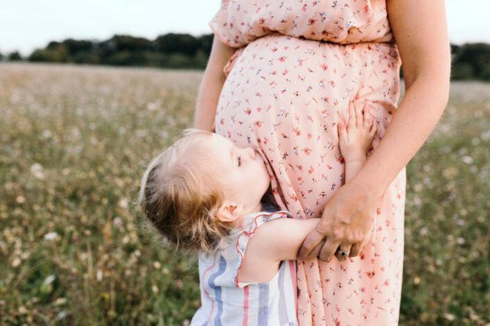 Little girl is kissing bump. Maternity photography in Hampshire. Ewa Jones Photography