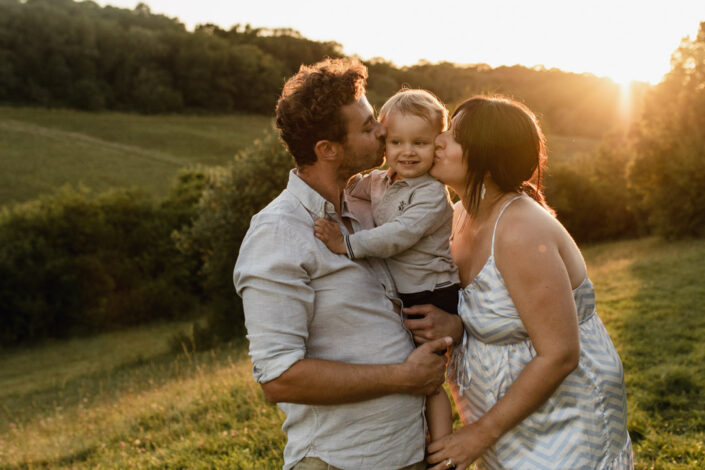 Mum and dad are kissing their toddler. Family and maternity photography in Hampshire. Ewa Jones Photography