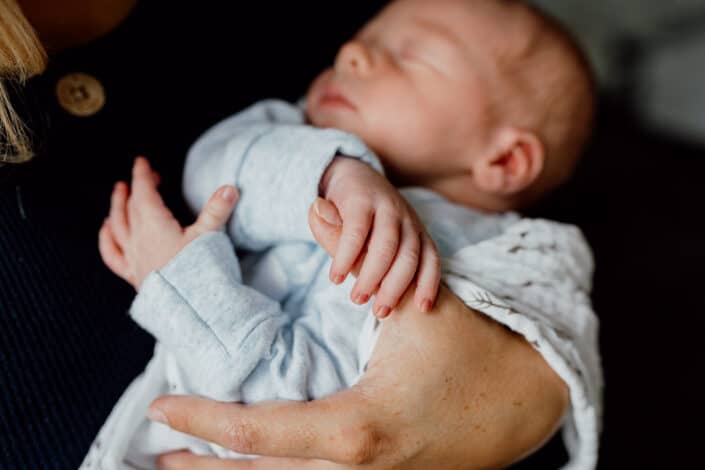 Newborn baby holding onto mum's thumb. Close up detail of a newborn baby little hands. Natural newborn baby photoshoot in Basingstoke, Hampshire, Ewa Jones Photography