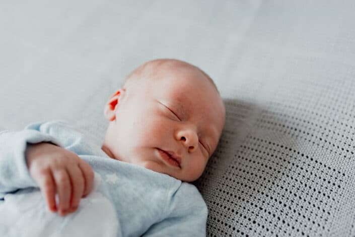 Newborn baby sleeping on the bed. Close up on a newborn face. Newborn baby photoshoot in Basingstoke, Hapmpshire. Ewa Jones Photography