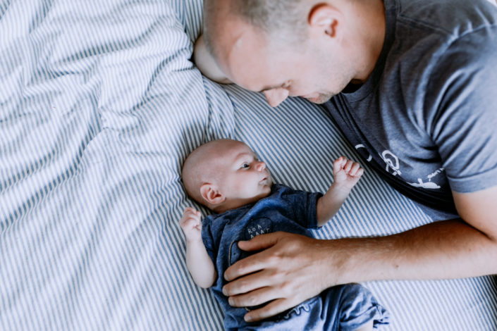 In home lifestyle newborn photo session | dad and baby on bed | Hampshire newborn photography | Ewa Jones Photography