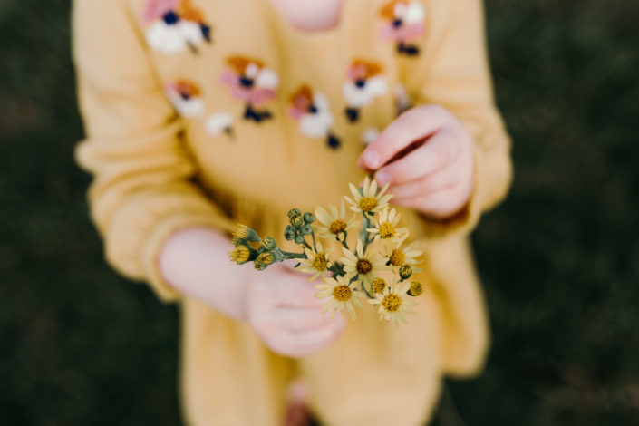 Girl in yellow dress in holding yellow flowers during sunset family photpshoot in Basingstoke. Hampshire. Ewa Jones Photography