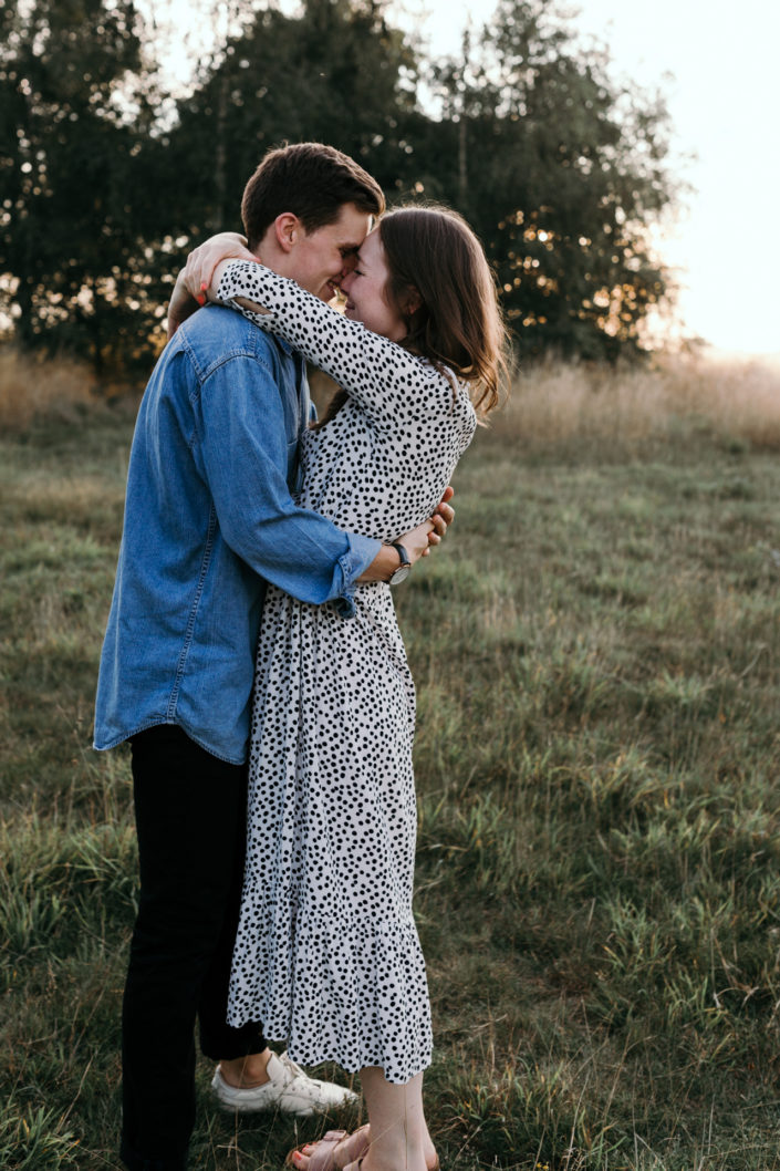 Couple is holding tight in the field. Hugging each other. Sunset family photoshoot in Basingstoke. Hampshire. Ewa Jones Photography