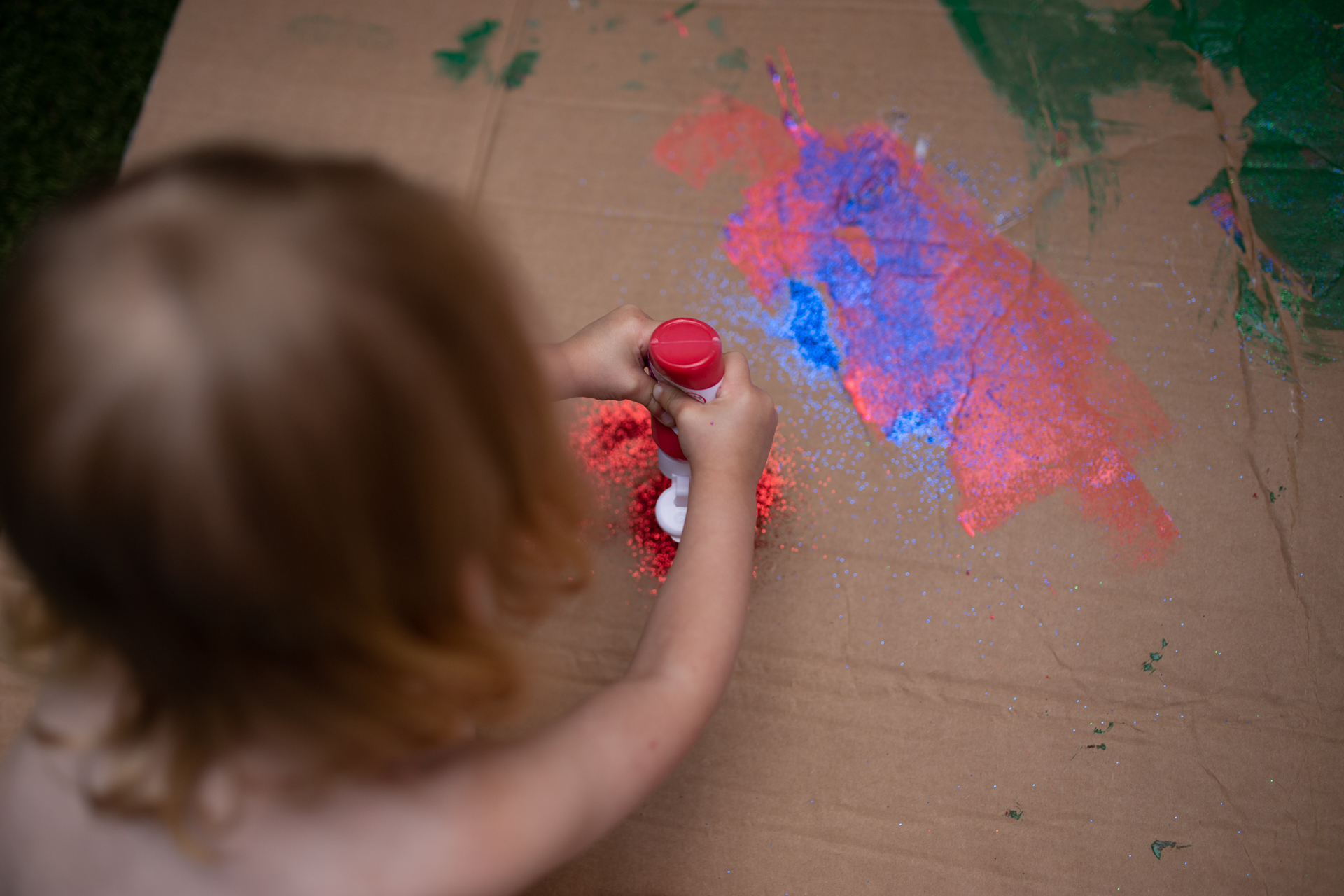 Girl painting with red paint by Ewa Jones Photography