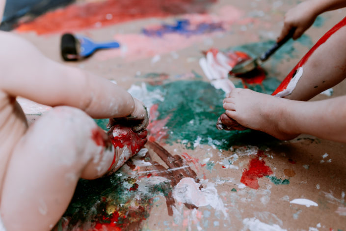 SIsters palying with paint and painting feet by Ewa Jones Photography