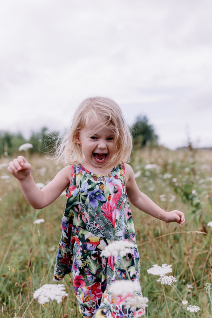 Girl running through wild flowers by Ewa Jones Photography