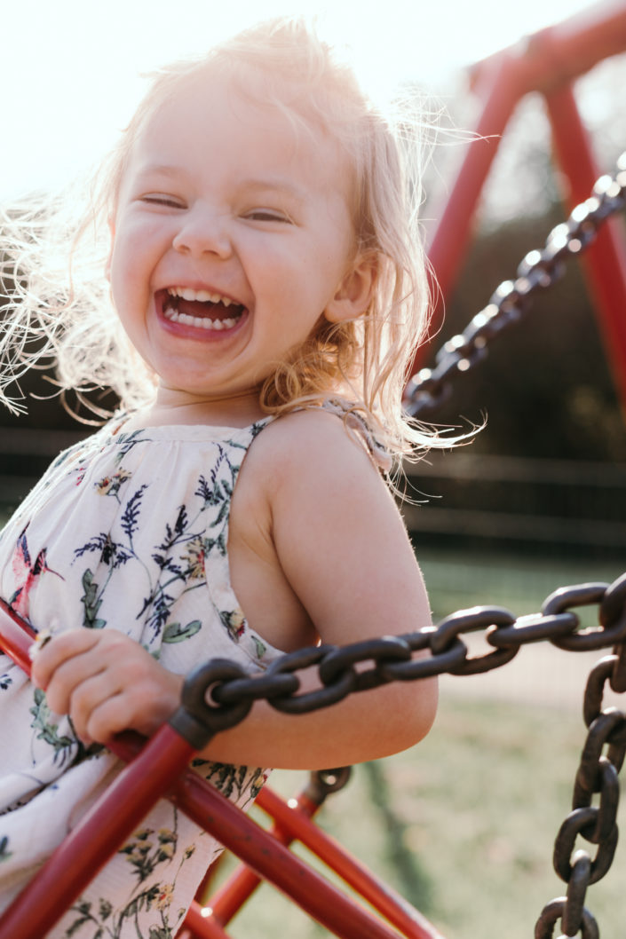 Girl on the swing smiling by Ewa Jones Photography