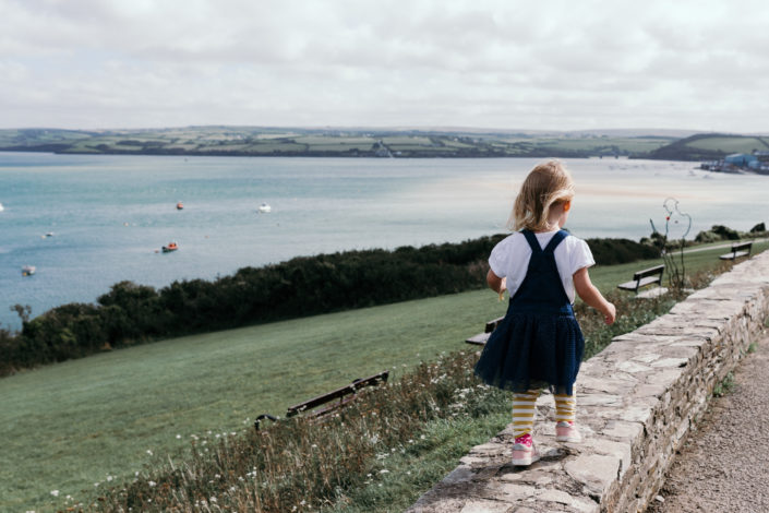 Girl walking on the wall in Padstow overlooking Doom Bar by Ewa Jones Photography