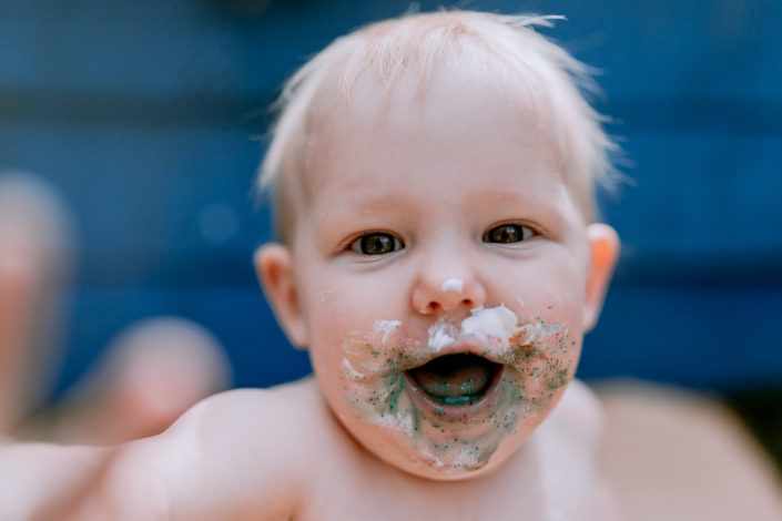 Happy girl with paint on her face by Ewa Jones Photography