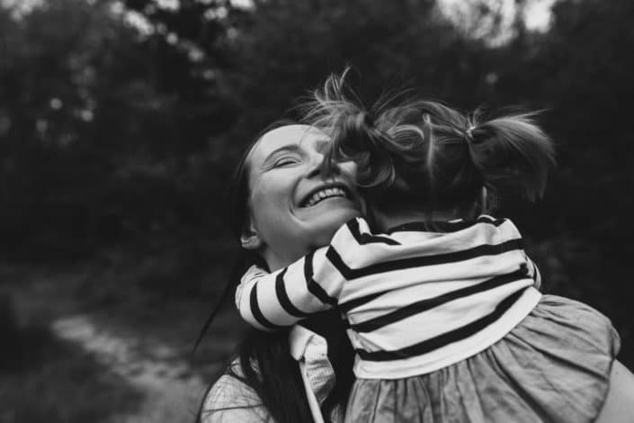 Mum is having cuddles with her daughter and smiling happily. family lifestyle photography in Hampshire. Ewa Jones Photography.