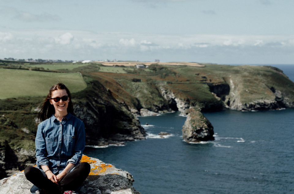 Girl sitting on the stone with the view of the sea and rocks. Ewa Jones Photography