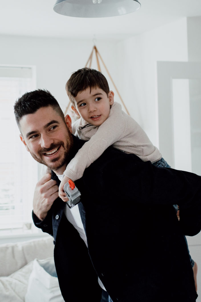 Dad is holding a son on his back. Piggy back. Family lifestyle photographer in Hampshire. Ewa Jones Photography