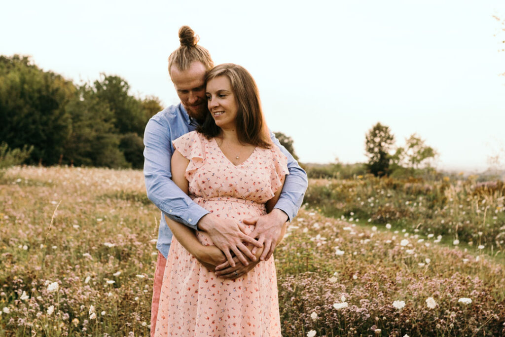Mum and dad are standing and holding each other. Both parents are holding bump. Lovely maternity photography in Hampshire. Ewa Jones Photography