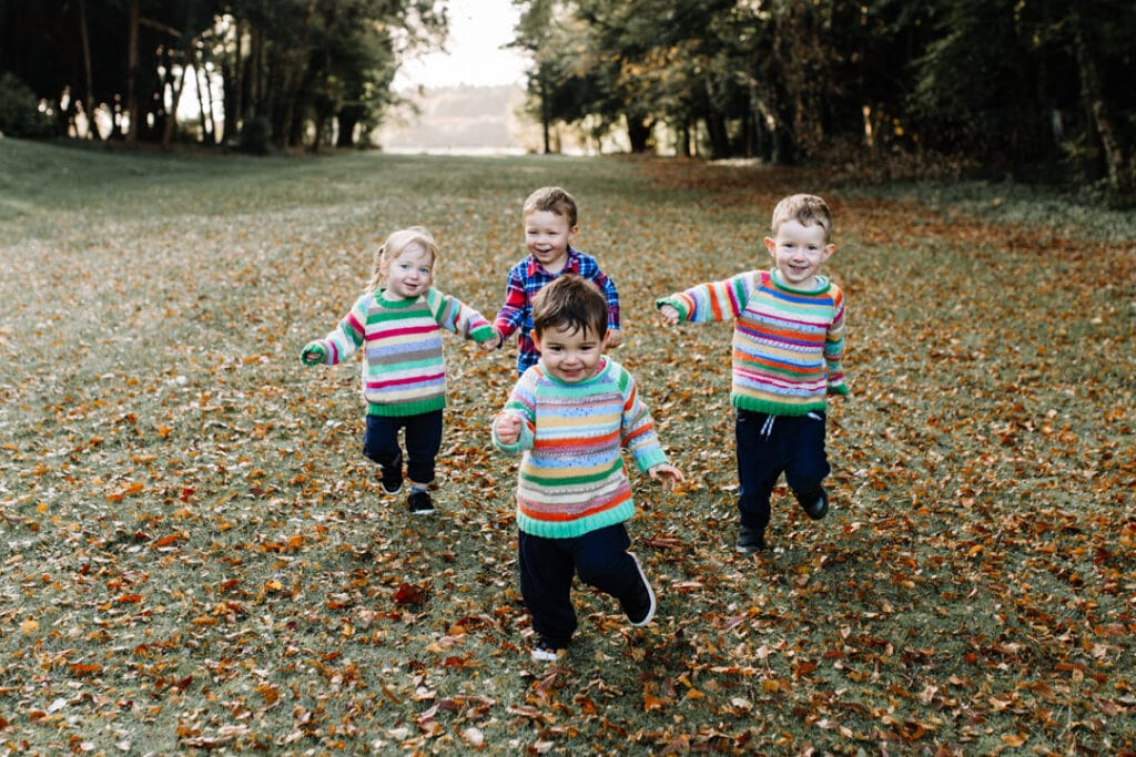 Kids are running in the field. All of them are laughing. Autumn family photography in Basingstoke. Ewa Jones Photography