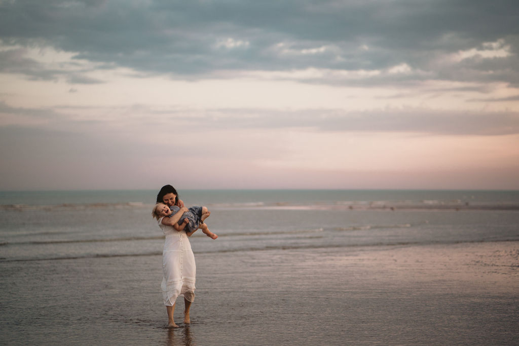 Mum is lifting little girl in the air. Family photo session