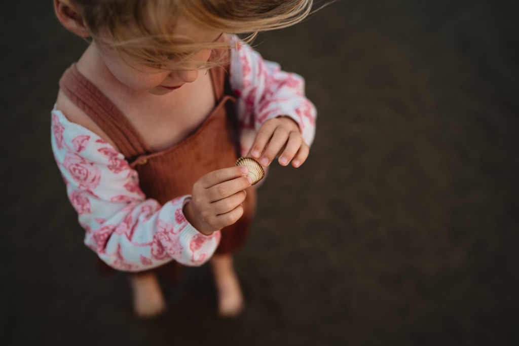 Close up of a girl holding a shell. Our first family photo session