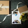 Photography gift vouchers. Gift voucher is in the middle lovely wrapped in tissue paper and inside brown box. on the side there are flowers and ribbons. Photography gift vouchers. Ewa Jones Photography