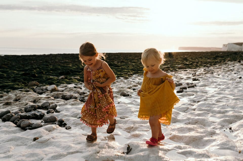 Family holiday in Hastings. Two little girls are walking on the beach at Seven sisters. Ewa Jones Photography