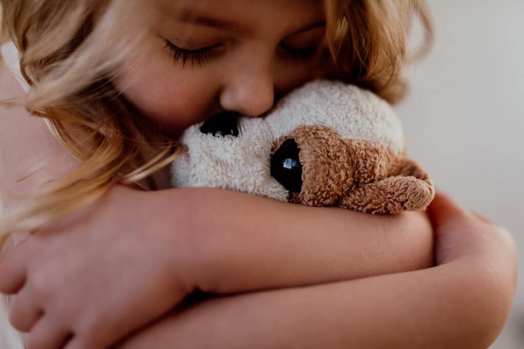 Little girl is cuddling her soft toy. Close up photograph. 7 tips on photographing kids at home. family photography in Hampshire. Ewa Jones Photography