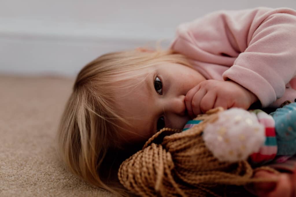Little girl is cuddling her soft toy. Close up photograph. 7 tips on photographing kids at home. family photography in Hampshire. Ewa Jones Photography