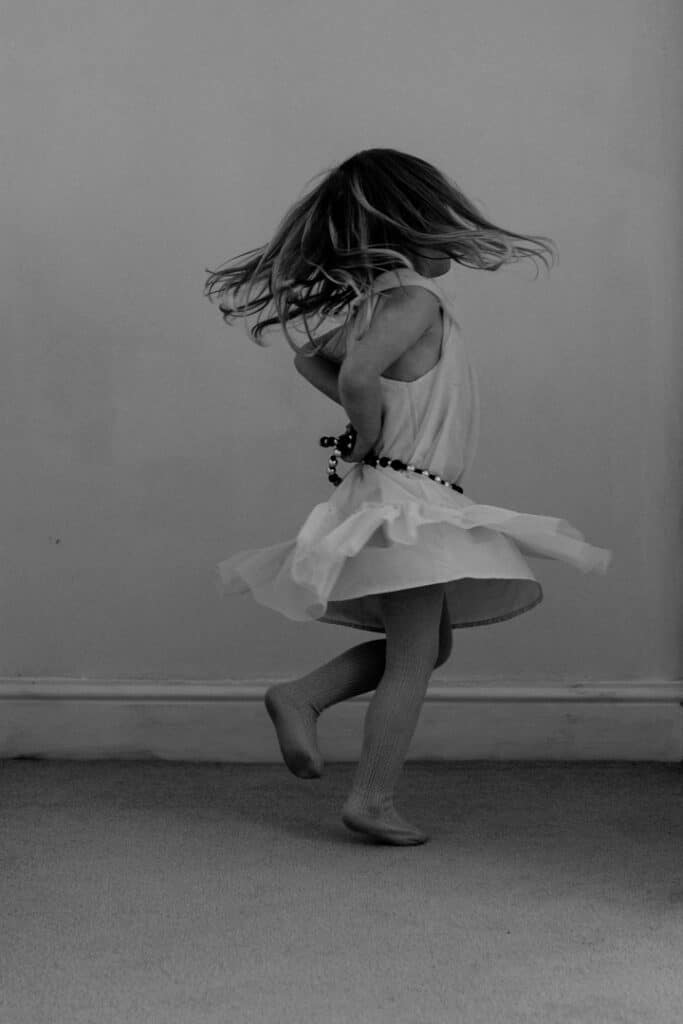Girl is dancing and has her dress spinning around. family photography in Basingstoke, Hampshire. Ewa Jones Photography