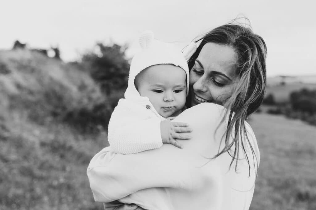 Mum is holding her baby boy and looking lovingly at him. Family photographer in Basingstoke, Hampshire. Ewa Jones Photography