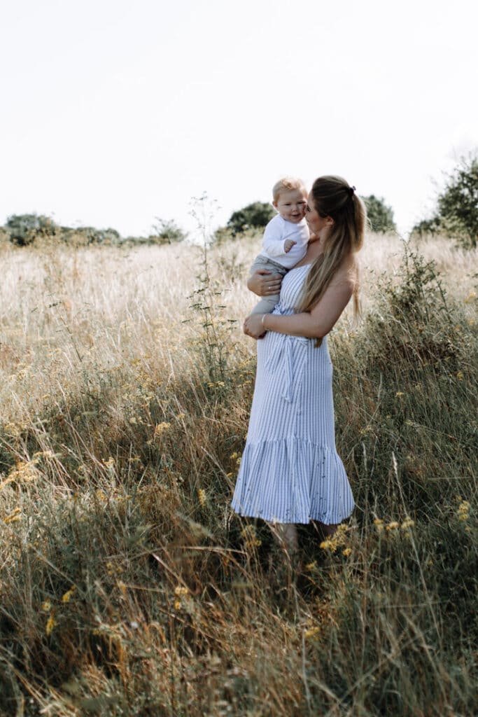 Mum is holding little baby boy and kissing him. Mummy and baby photography in Basingstoke, Hampshire, Ewa Jones Photography