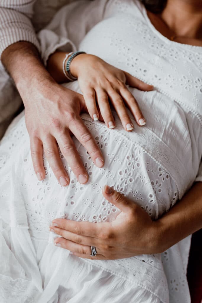 close up detail of baby bump. Mum and dad are holding baby bump. Lovely maternity photography in Hampshire. Ewa Jones Photography