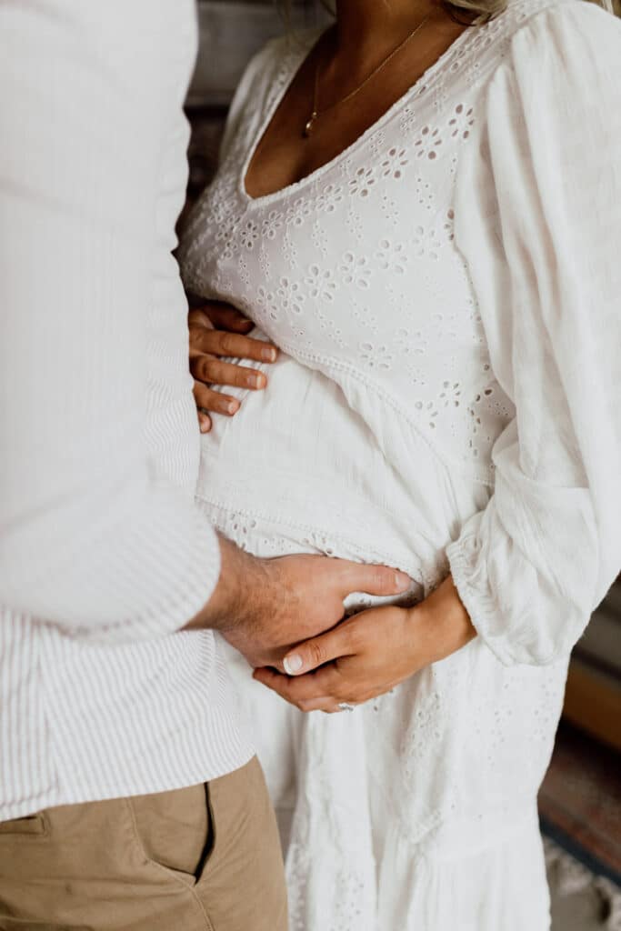 Mum to be is holding her baby bump. Lovely in home maternity photo session in Hampshire. Ewa Jones Photography