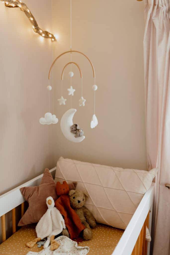 Close up of baby cot with lovely toys and cot mobile. In home maternity photo session in Hampshire. Ewa Jones Photography