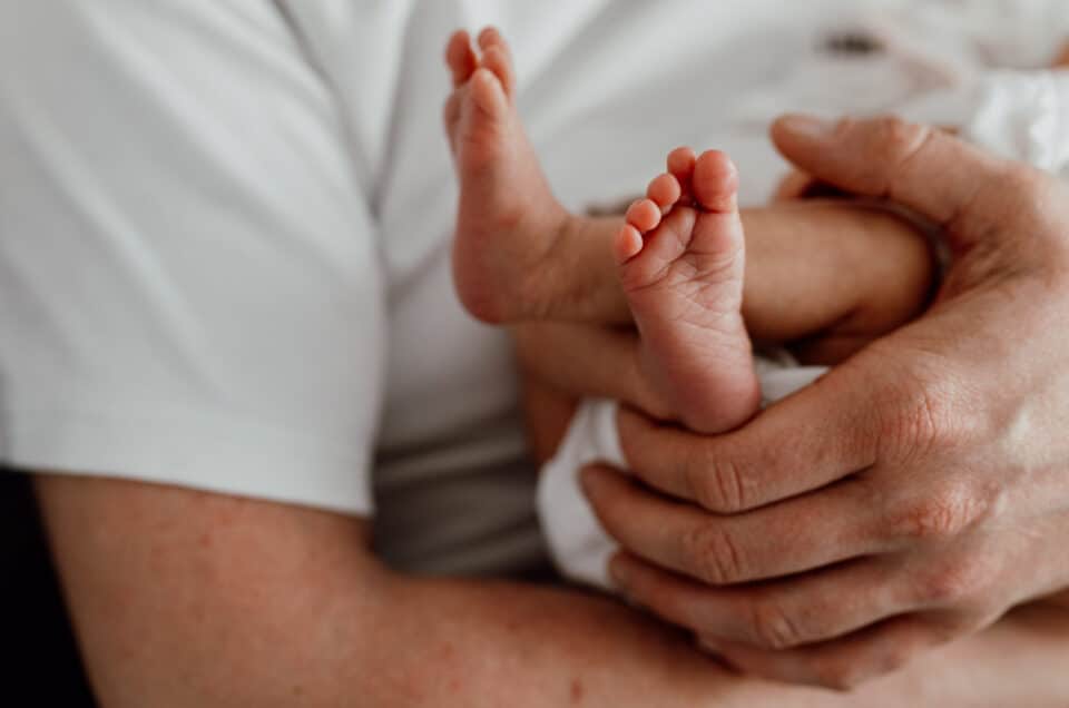 Close up feet details of the newborn baby feet. Dad is holding his baby girl in his hands. Newborn photography in Hampshire. Ewa Jones Photography