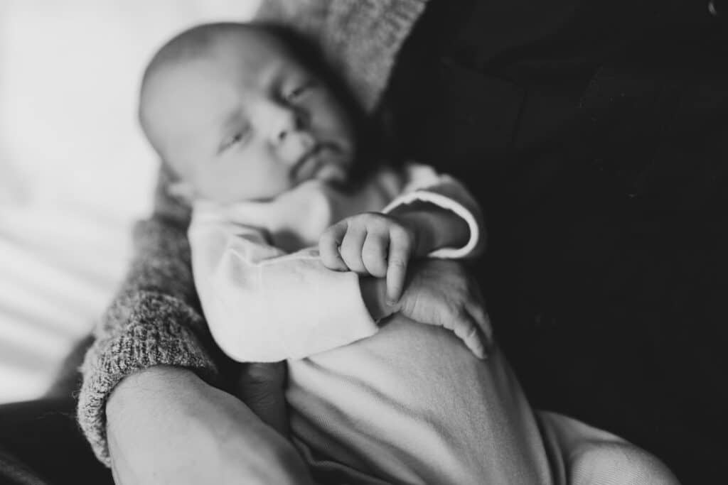 Black and white photograph of newborn baby hands. Lifestyle photography in Hampshire. Ewa Jones Photography
