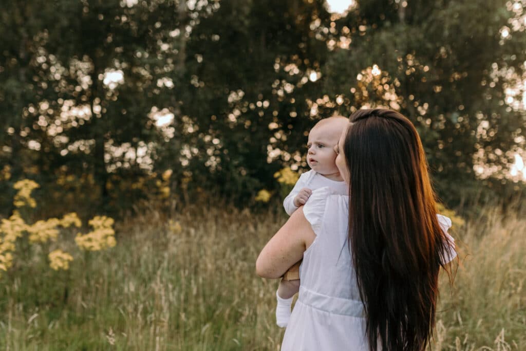 Mum is standing back to the camera and her little boy is looking away. Lovely sunset photosession. Family photography in Hampshire. Ewa Jones Photography