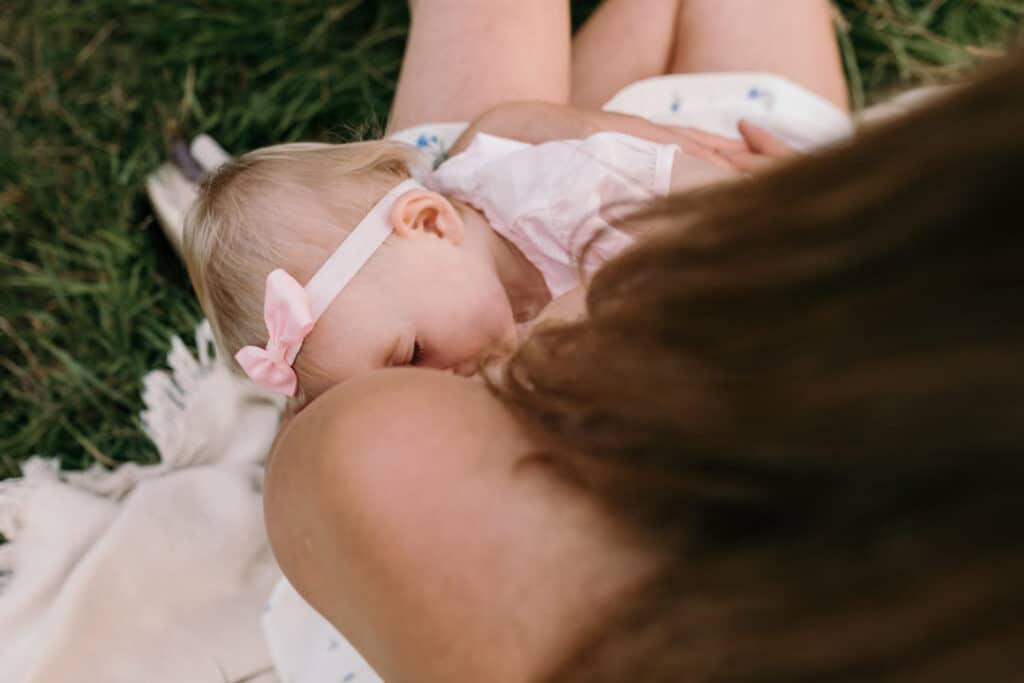 Mum is breastfeeding her girl. Lovely candid photograph of mum and her baby. World breastfeeding week. Breastfeeding photo session in Basingstoke, Hampshire. Family photographer in Basingstoke, Ewa Jones Photography