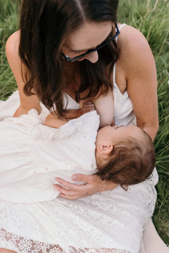 Mum is breastfeeding her girl. Lovely candid photograph of mum and her baby. World breastfeeding week. Breastfeeding photo session in Basingstoke, Hampshire. Family photographer in Basingstoke, Ewa Jones Photography