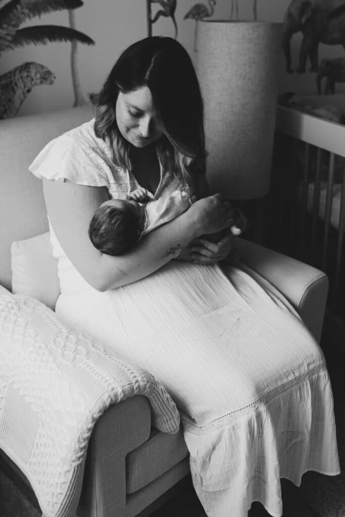 Mum is holding her newborn baby girl. Lovely natural light is coming through the windows. Newborn photographer in Hampshire. Ewa Jones Photography