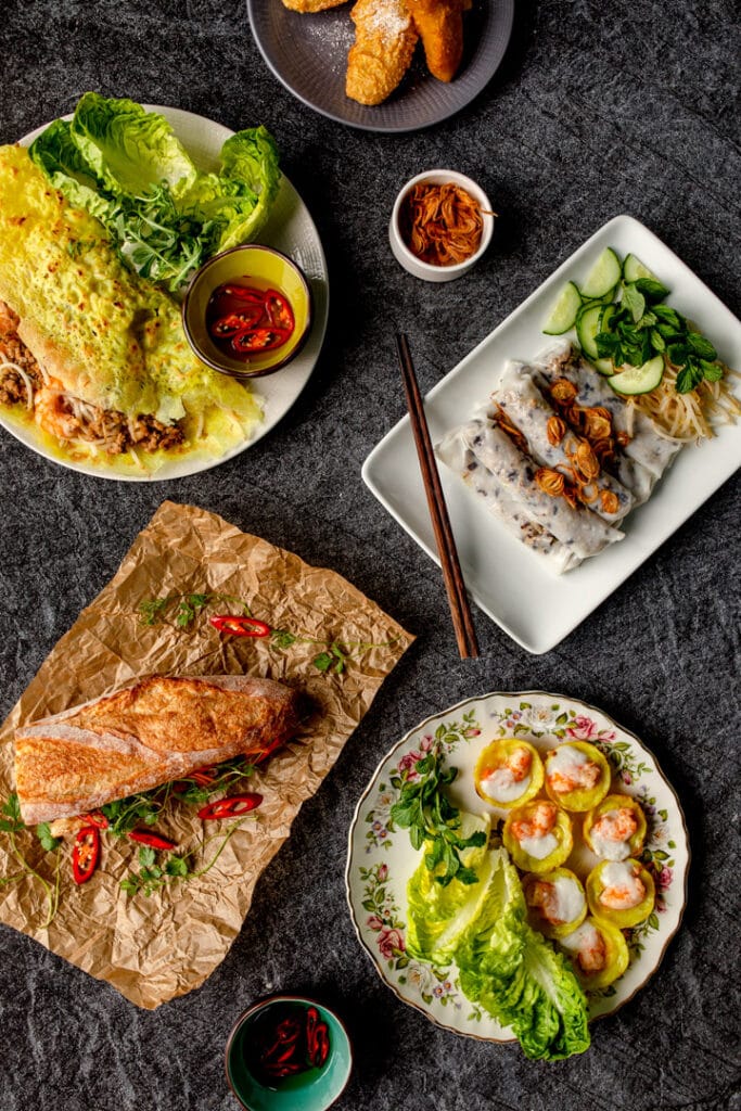 Variety of Vietnamese food including rice rolls, mini pancakes, fried bananas, chicken in bun. Food photography with Banana Blossom. Ewa Jones Photography