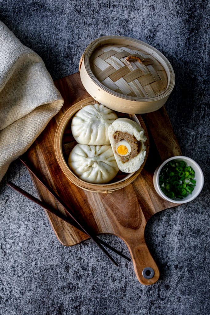 Authentic Vietnamese buns inside bamboo container and on a wooden chopping board. Food photography with Banana Blossom. Ewa Jones Photography