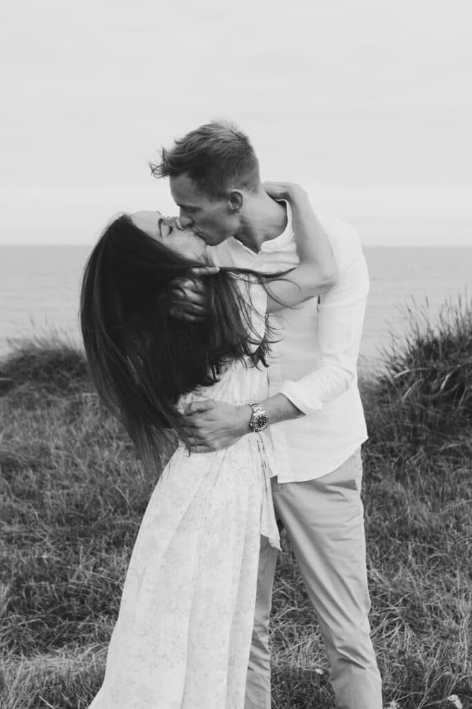 Couple is holding tight and kissing each other. They are by the beach. Romantic couple photography in Hampshire. Ewa Jones Photography