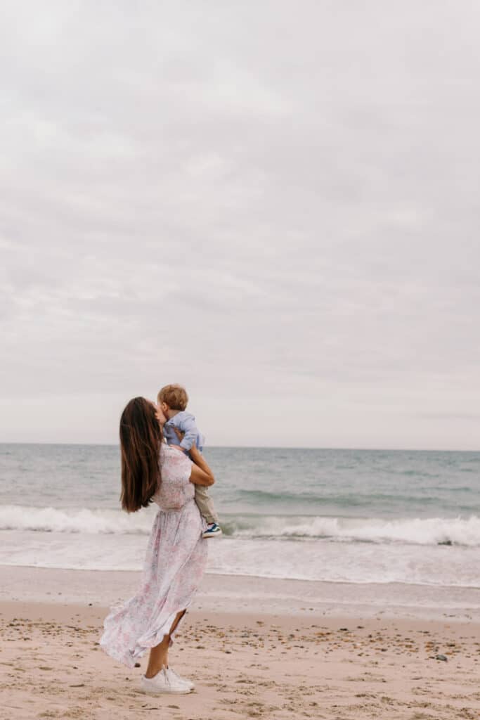 Mum is kissing her little boy. They are at the beach. Lovely candid family photograph. Hampshire family photographer. Ewa Jones Photography