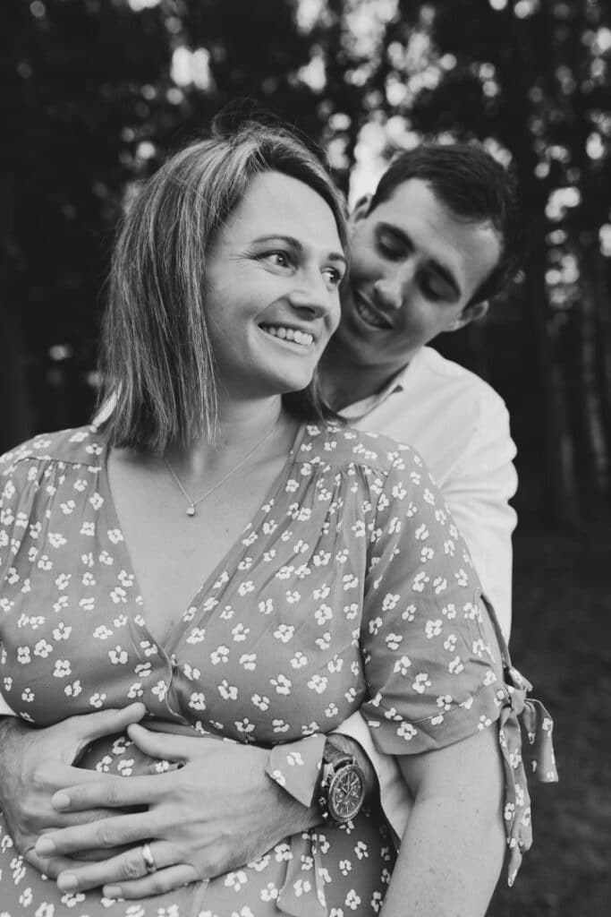 Black and white photograph of expecting mum and her husband. Her husband is looking at her lovingly. Lovely maternity photography in Hampshire. Ewa Jones Photography