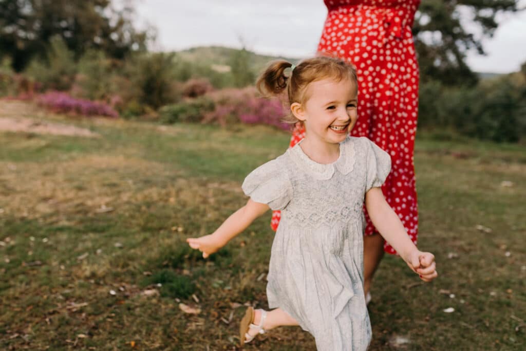 little girl is running and laughing. family photographer in Basingstoke, Hampshire. Ewa Jones Photography