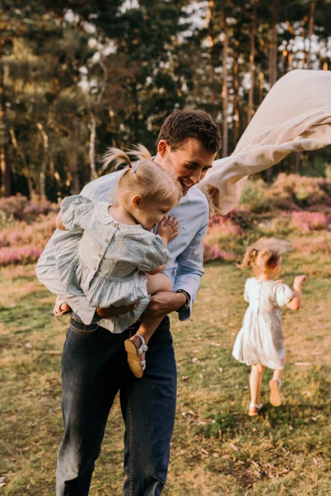 dad is running with his daughter and laughing. lovely family photograph during family photo session. family photographer in Hampshire. Ewa Jones Photography