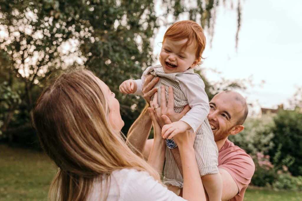 family photo session in Hampshire. Dad is lifting up his son who is laughing. family photo shoot during golden hour. family photographer in Hampshire. Ewa Jones Photography