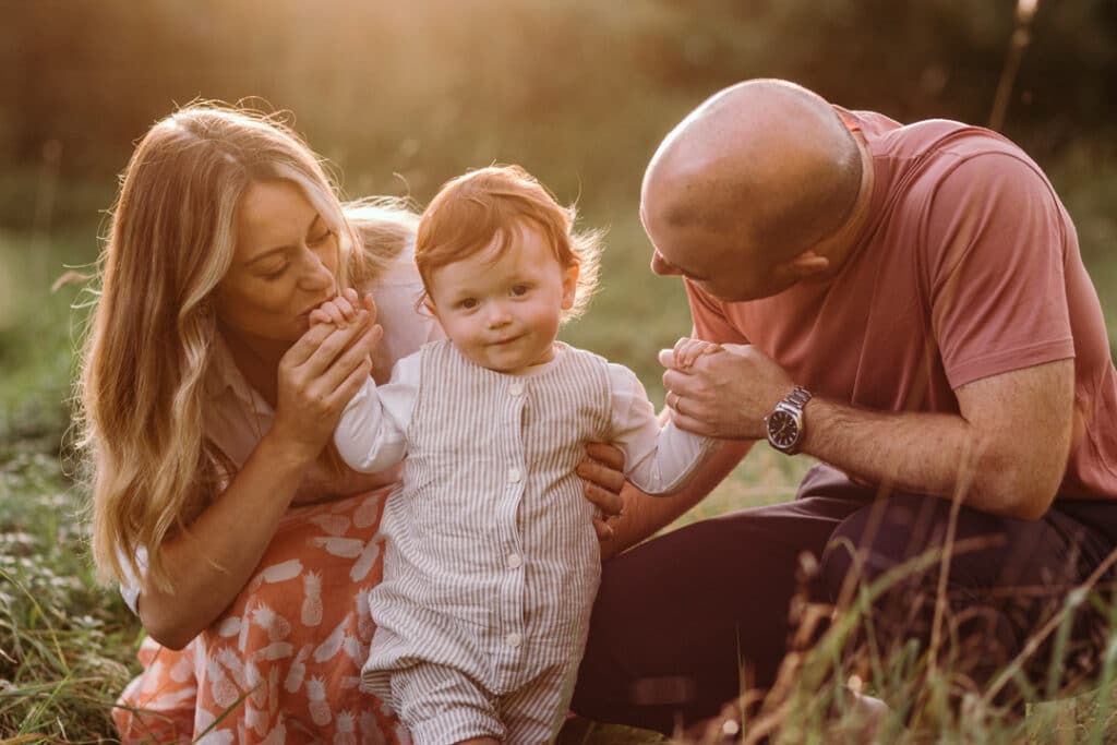 Mum and dad are looking at the boy and he is looking at the camera. natural lifestyle family photo session in Hampshire. Ewa Jones Photography